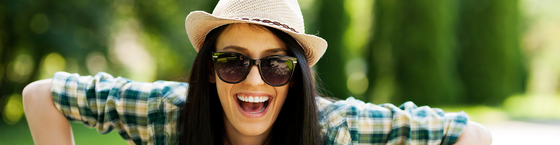 Faqs. Girl on bike smiling with hat.