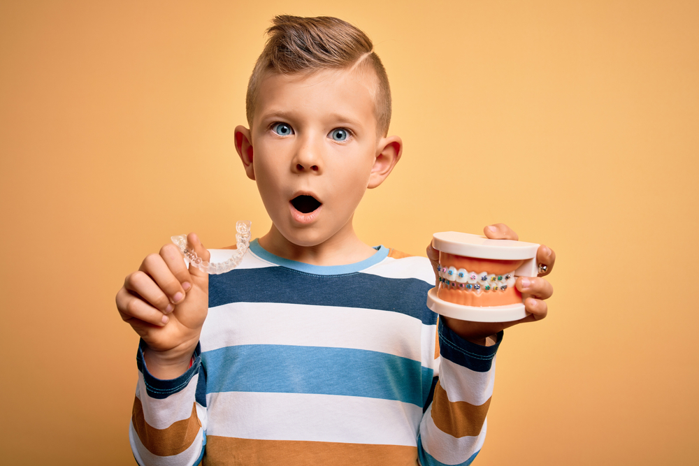 Little,Kid,Boy,Holding,Professional,Orthodontic,Denture,With,Metal,Braces