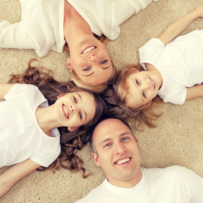 parents and two girls lying on floor at home