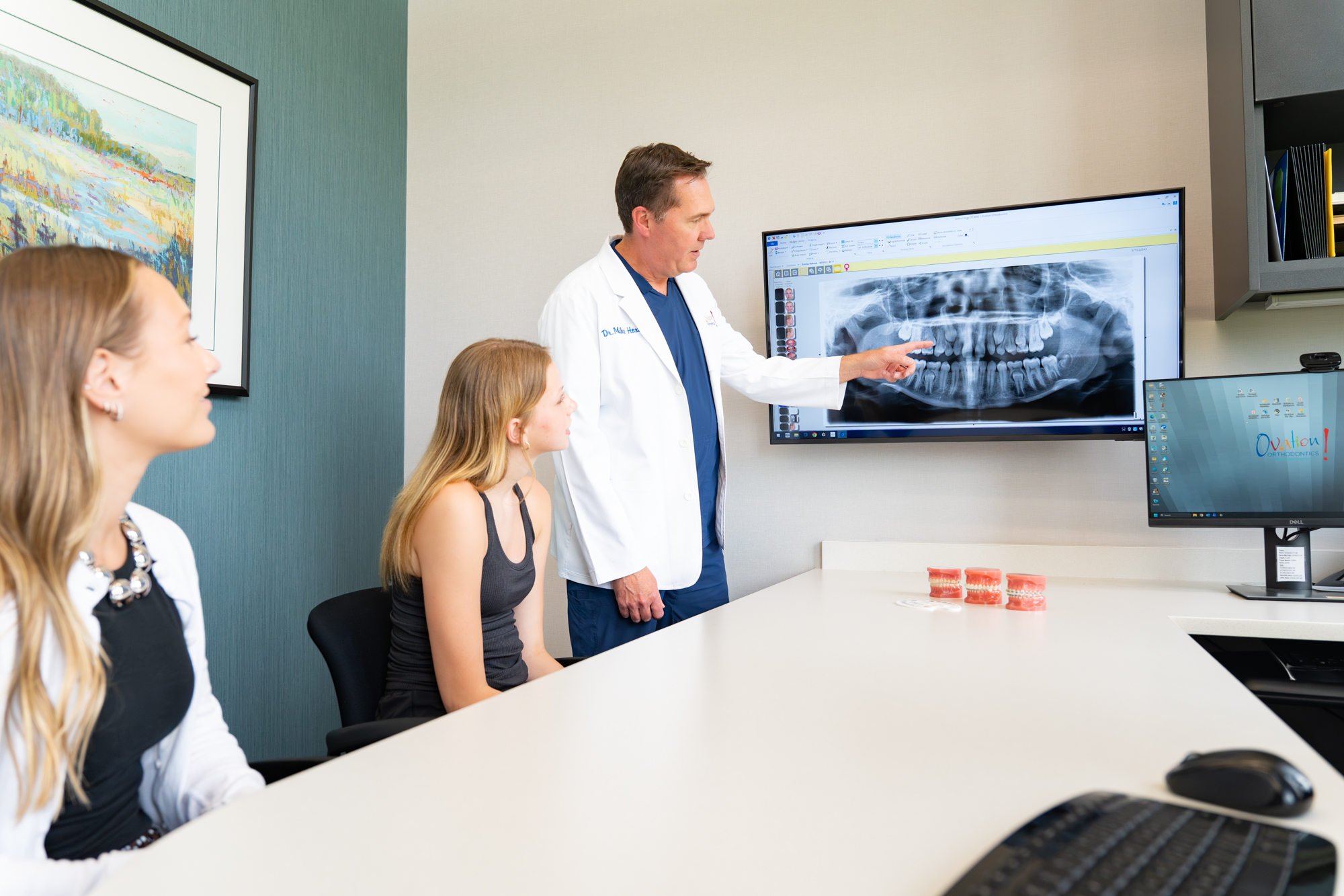 Orthodontist reviewing a patient's X-ray at Ovation Orthodontics