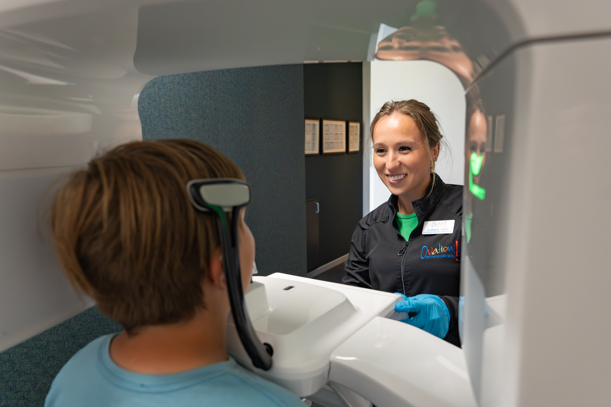 Orthodontic assistant helping a patient with a 3D X-ray at Ovation Orthodontics