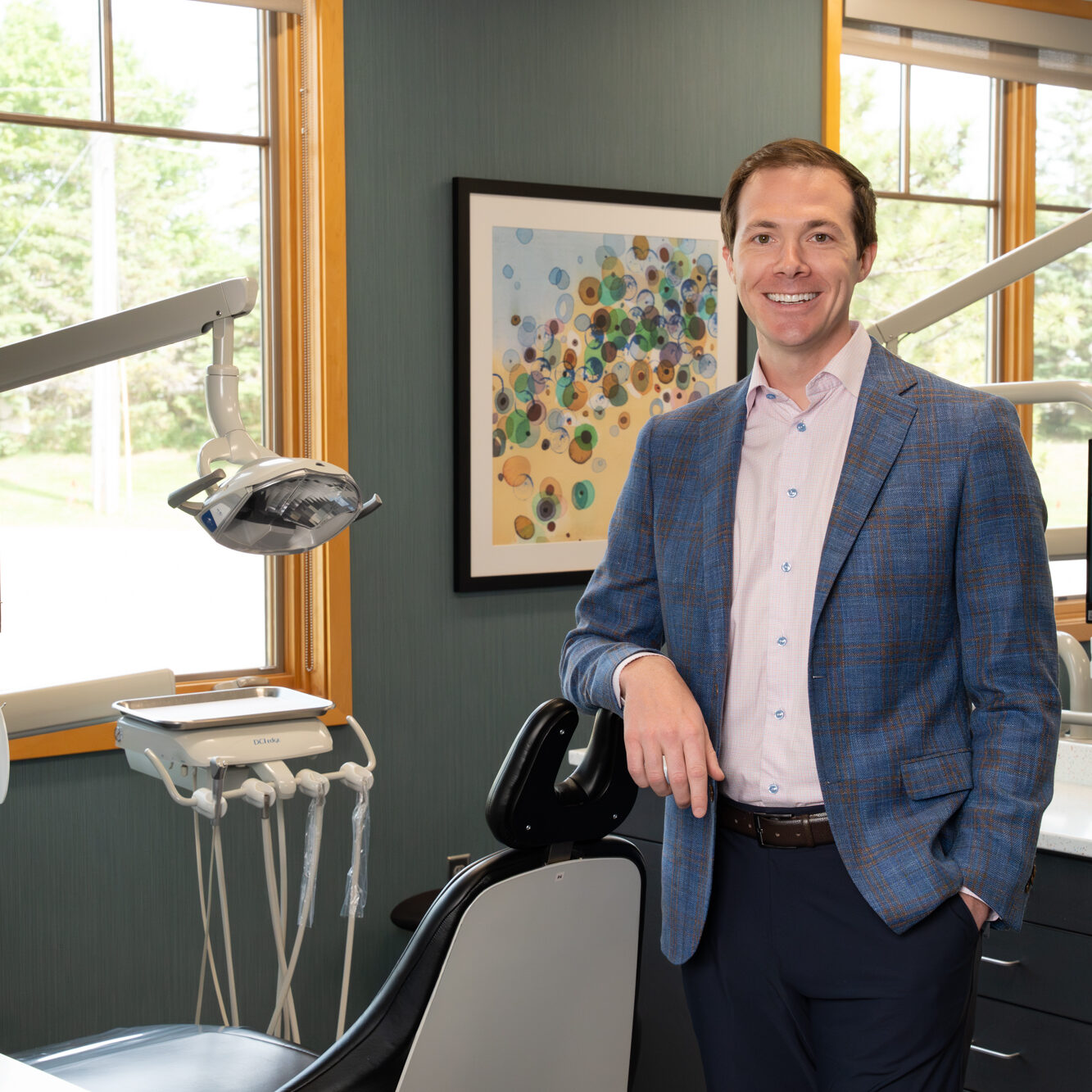 Dr. Adam Hoxie, orthodontist at Ovation Orthodontics, smiling in dental office setting.